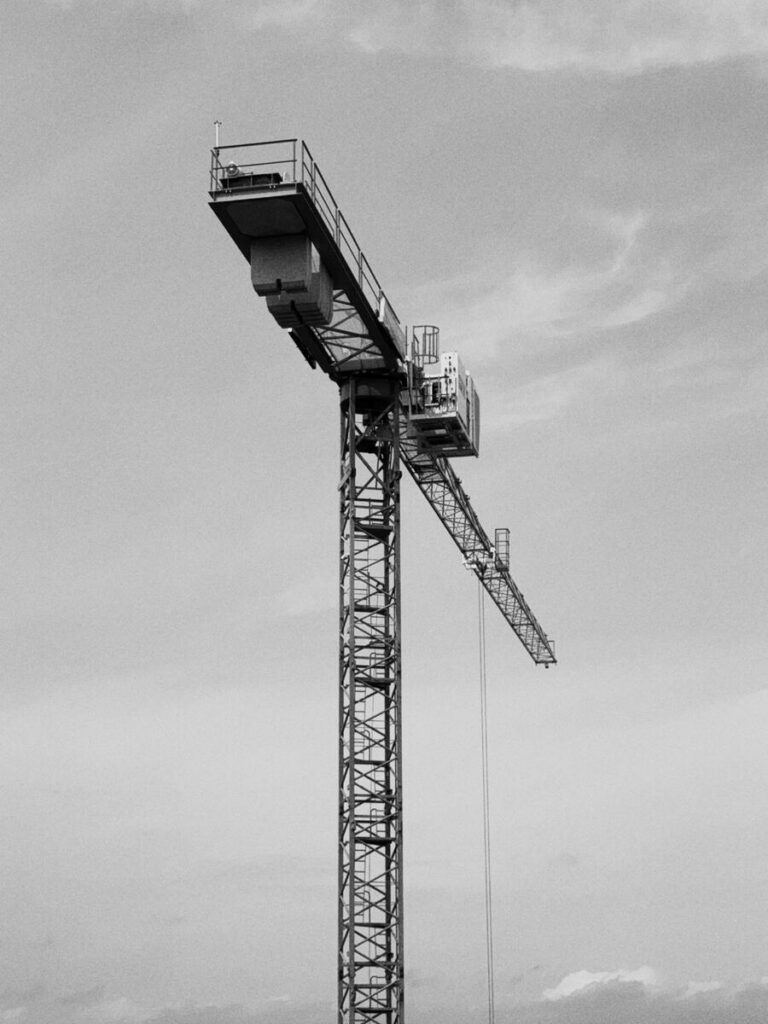 Tower crane against an overcast sky, black and white