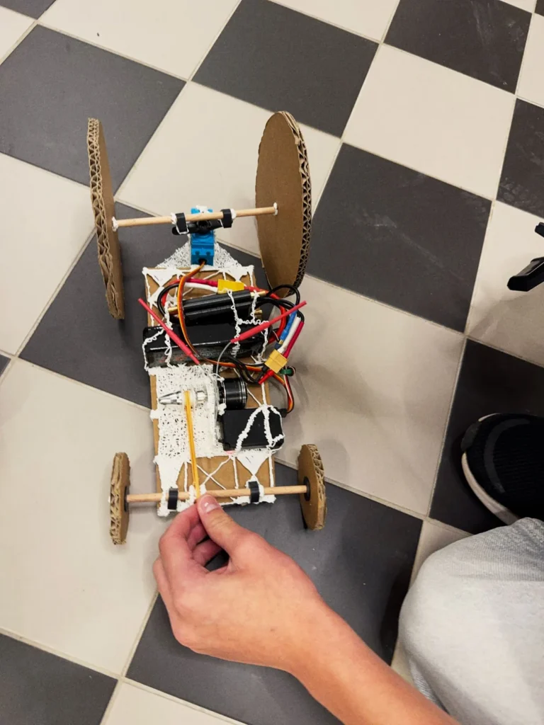 A cardboard car with large disc wheels seen from above